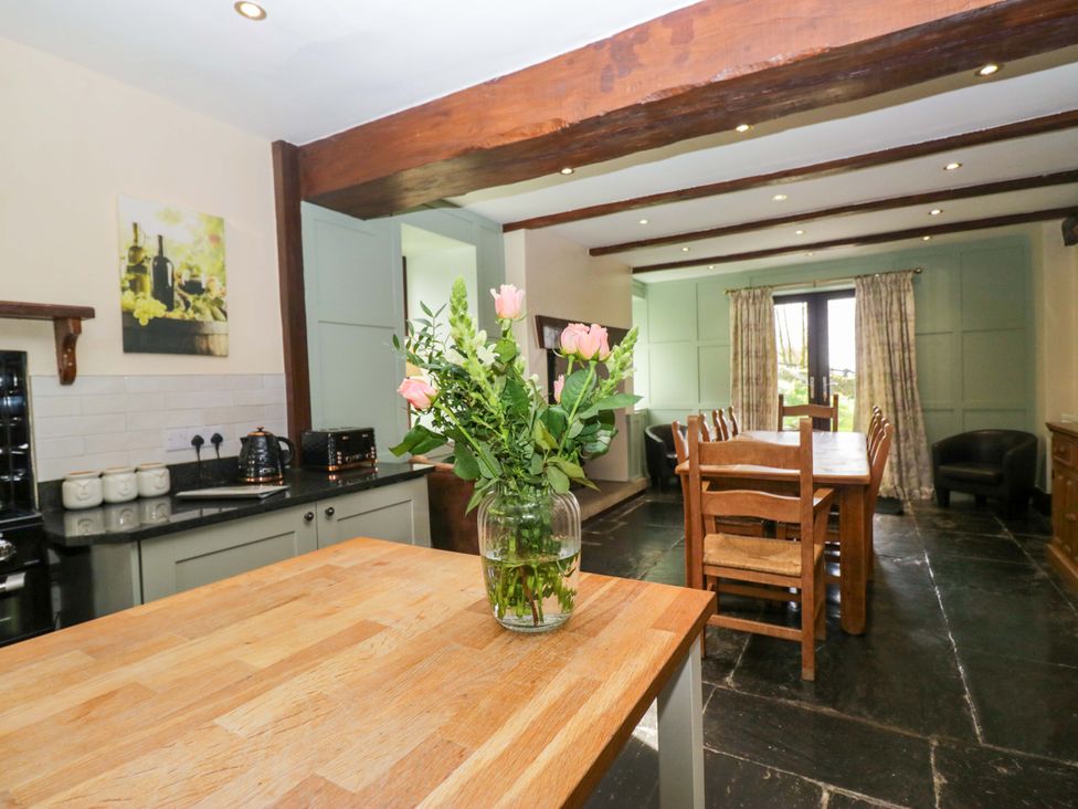 A kitchen with a dining table and flowers at Ewedale Farm Pennington near Ulverston