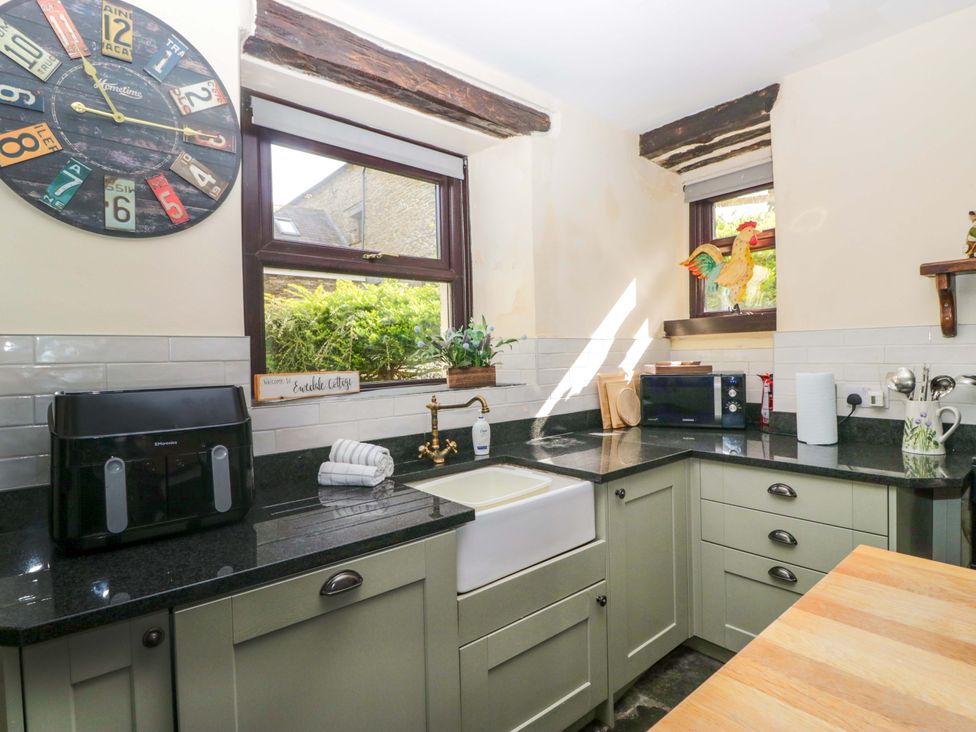 A kitchen with a sink and clock at Ewedale Farm in Pennington near Ulverston