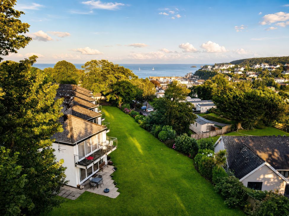 An outdoor view of buildings and ocean at 6 Coedrath Park - Swn y Mor in Saundersfoot