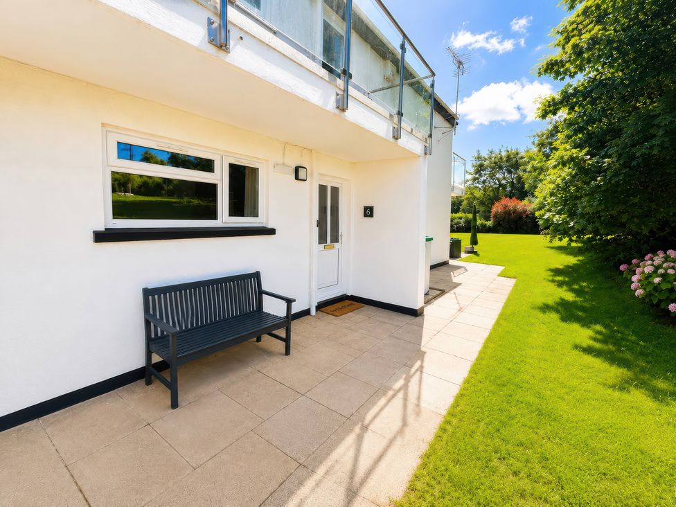 An outdoor area with a bench and door at 6 Coedrath Park - Swn y Mor, Saundersfoot