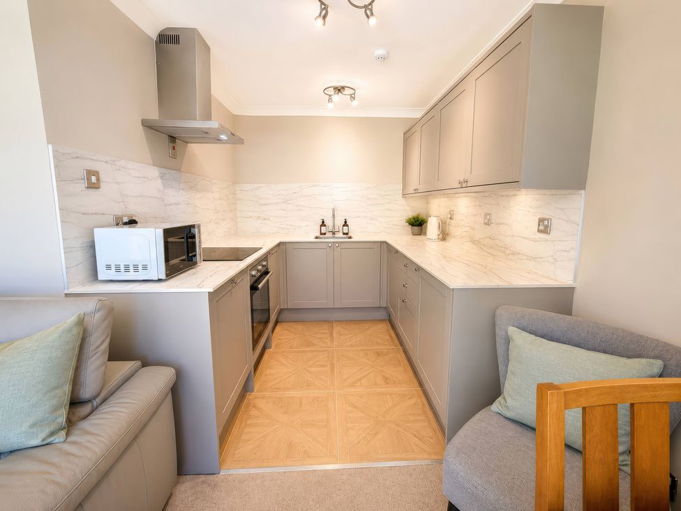 A kitchen with appliances and cabinets at 6 Coedrath Park - Swn y Mor, Saundersfoot