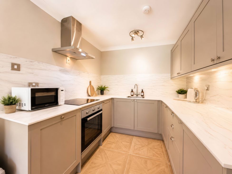 A kitchen with cabinets and appliances at 6 Coedrath Park - Swn y Mor in Saundersfoot