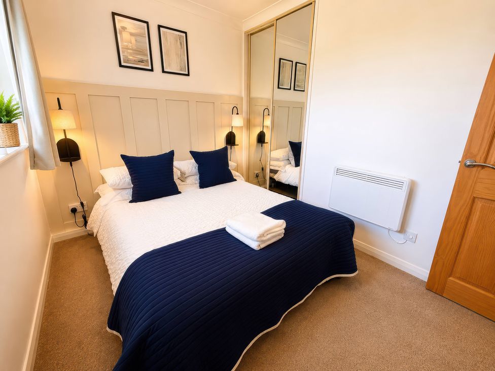 A bedroom with a bed and lamps at 6 Coedrath Park - Swn y Mor in Saundersfoot
