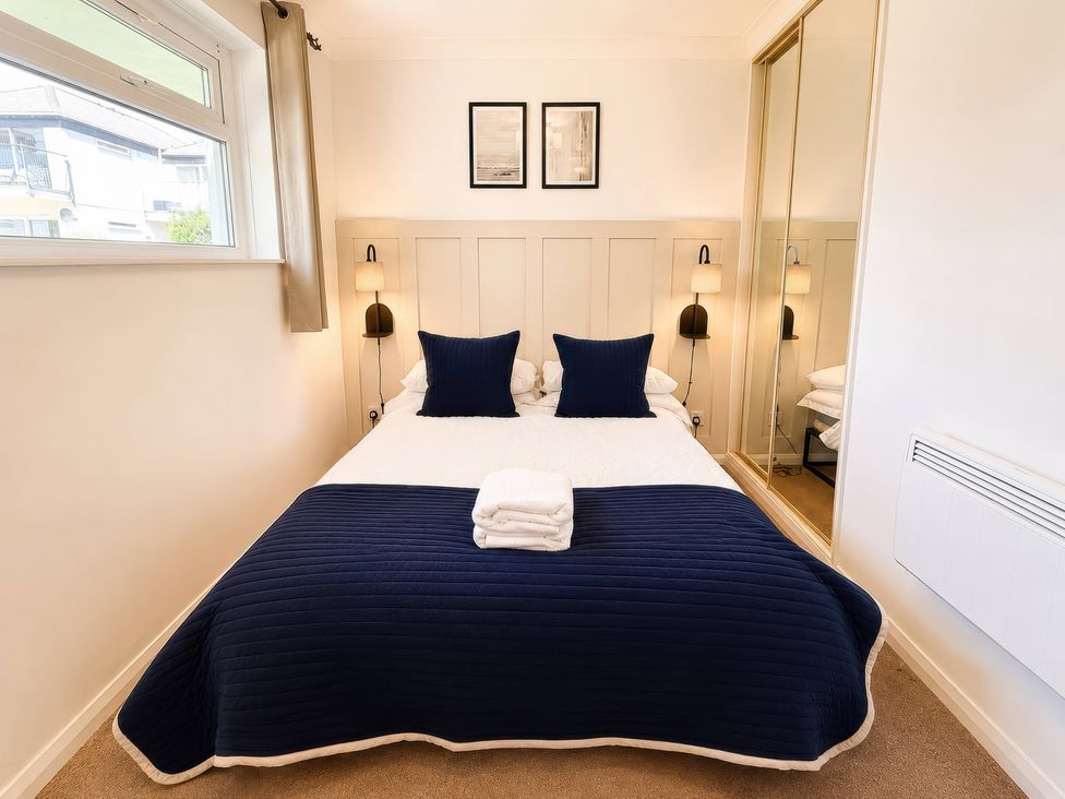 A bedroom with a bed and wall art at 6 Coedrath Park - Swn y Mor Saundersfoot