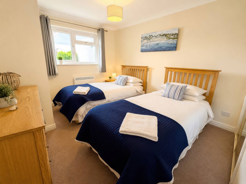 A bedroom with two beds and a window at 6 Coedrath Park - Swn y Mor Saundersfoot