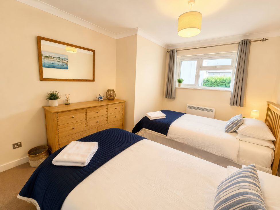A bedroom with two beds and a dresser at 6 Coedrath Park - Swn y Mor in Saundersfoot