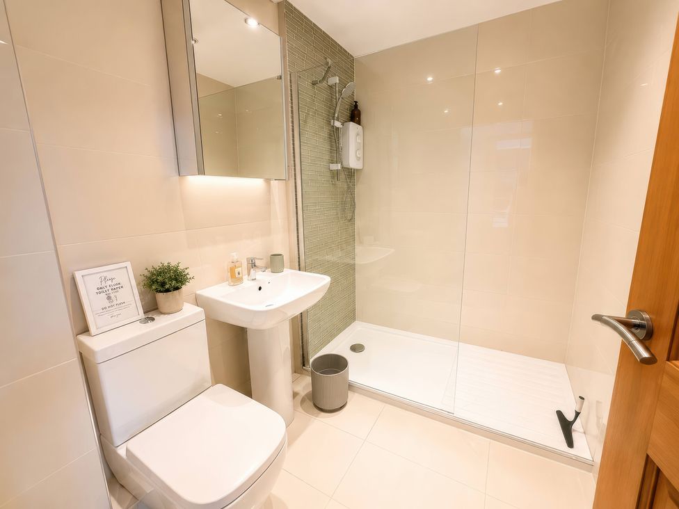 A bathroom with a shower, sink, and toilet at 6 Coedrath Park - Swn y Mor in Saundersfoot