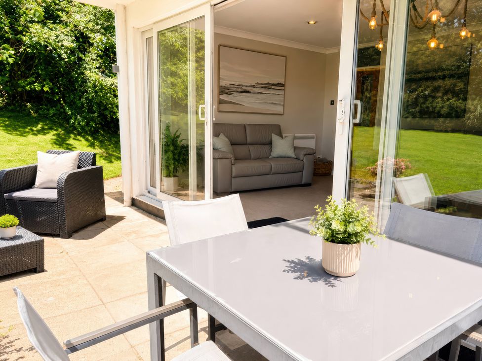 An outdoor seating area with table and chairs at 6 Coedrath Park - Swn y Mor, Saundersfoot