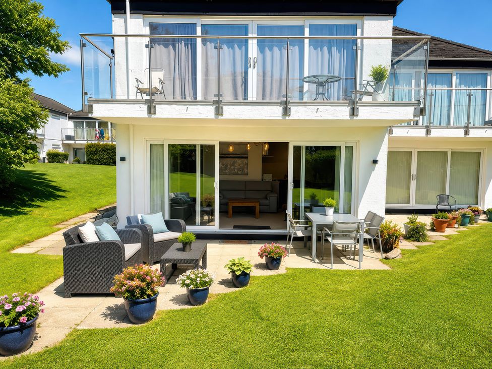 An outdoor patio with seating and plants at 6 Coedrath Park - Swn y Mor in Saundersfoot
