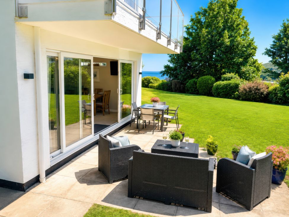 An outdoor patio area with seating and a table at 6 Coedrath Park - Swn y Mor in Saundersfoot