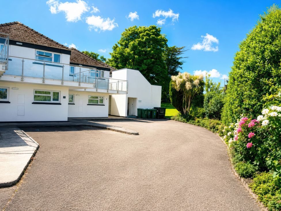 A building with a balcony and parking lot at 6 Coedrath Park - Swn y Mor Saundersfoot