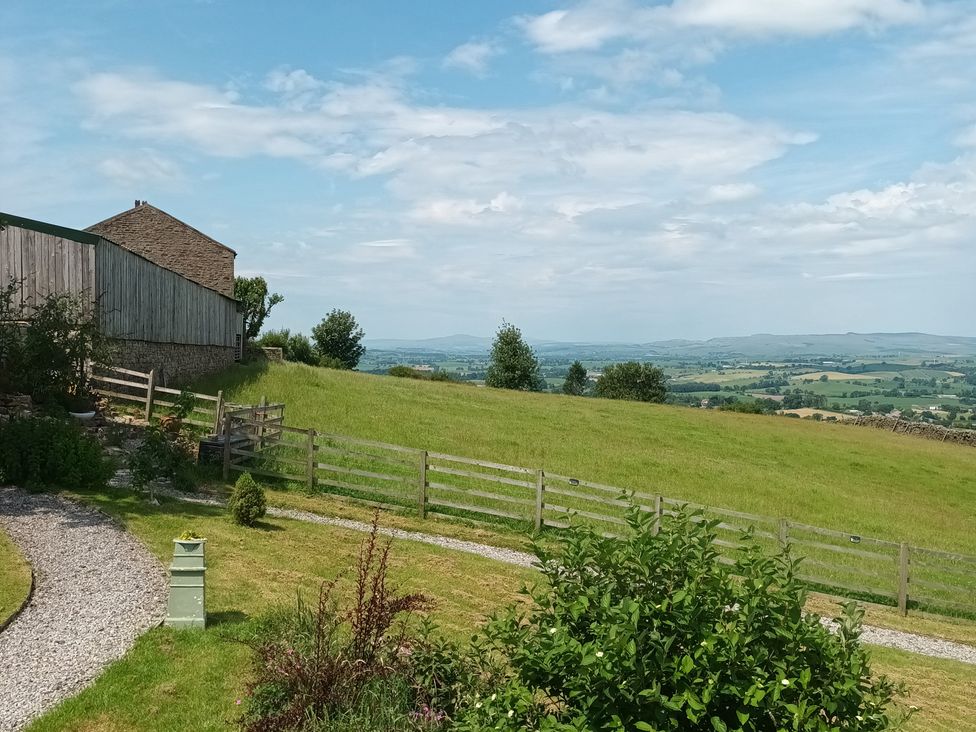 A house and field with trees and a fence at The Journeyman Luxury Shepherds Hut Barnoldswick