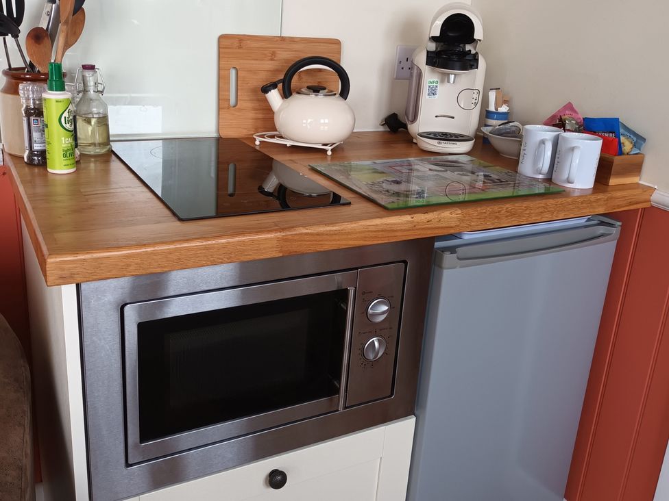A kitchen with a microwave and kettle at The Journeyman Luxury Shepherds Hut Barnoldswick