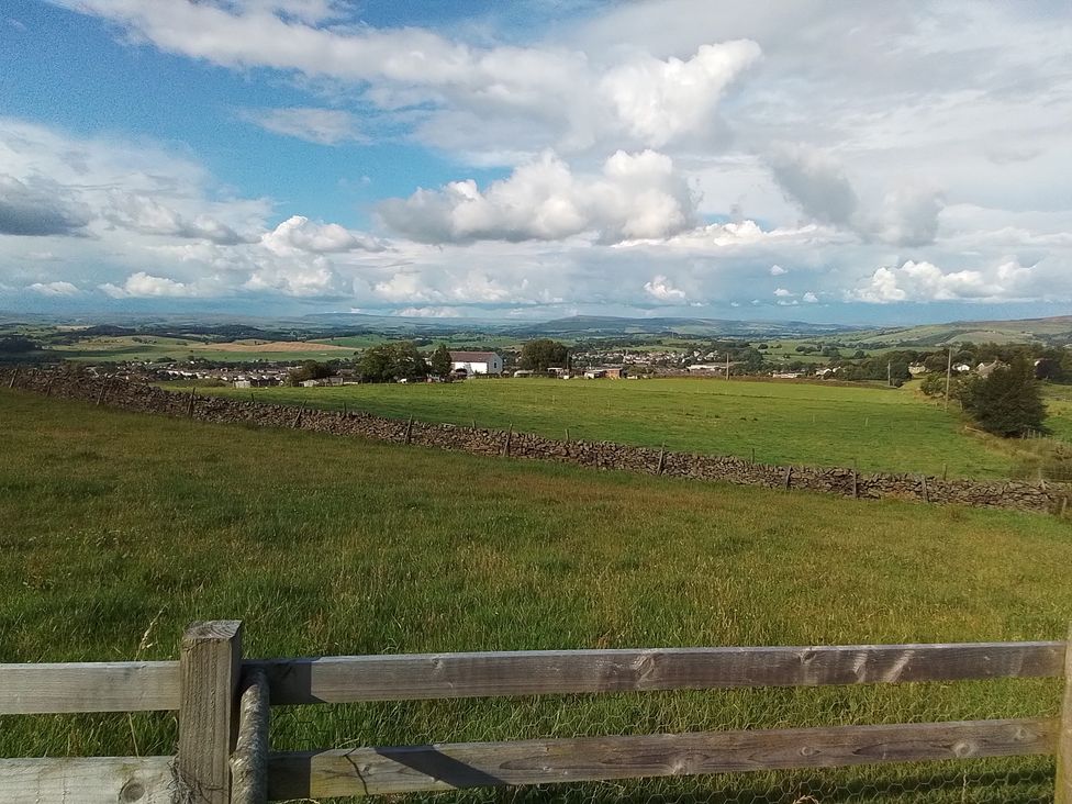 A landscape view showing fields and distant hills at The Journeyman Luxury Shepherds Hut in Barnoldswick