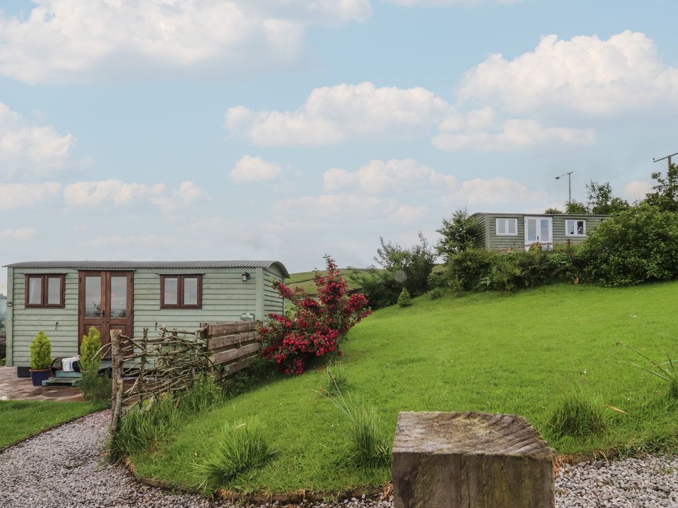 An outdoor area with a shepherd's hut and grassy landscape at The Journeyman Luxury Shepherds Hut Barnoldswick