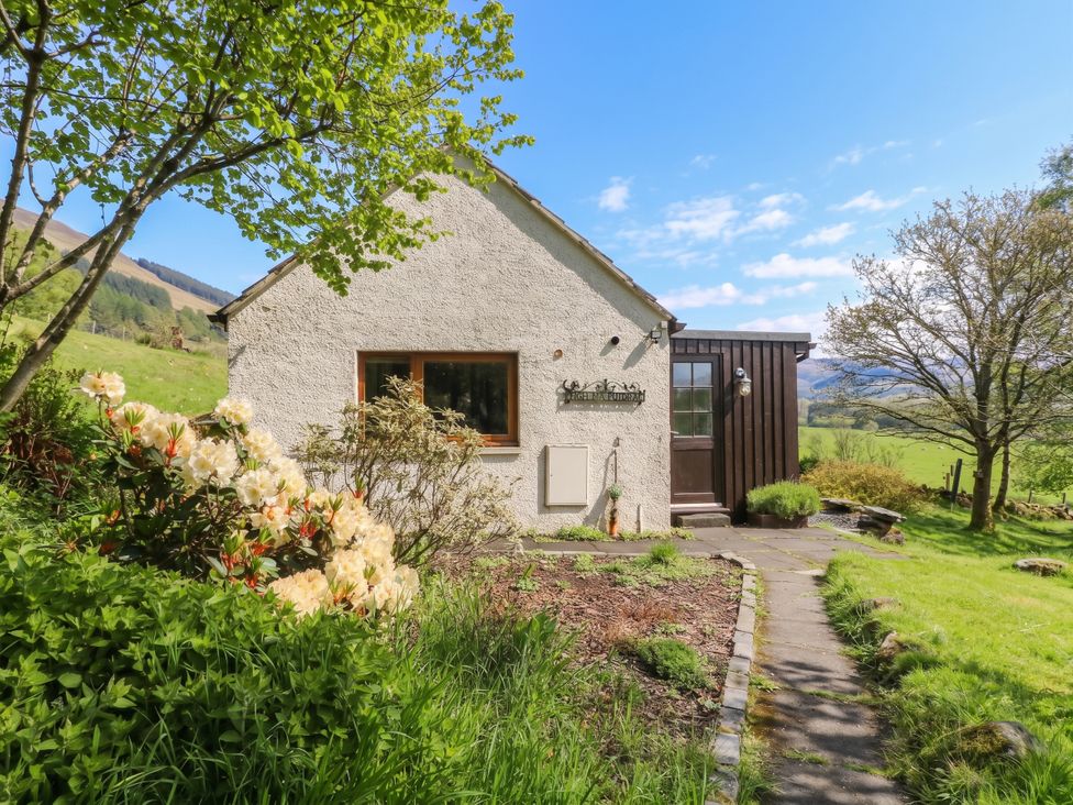 A house with a pathway and garden at Puidrac Cottage in Balquhidder