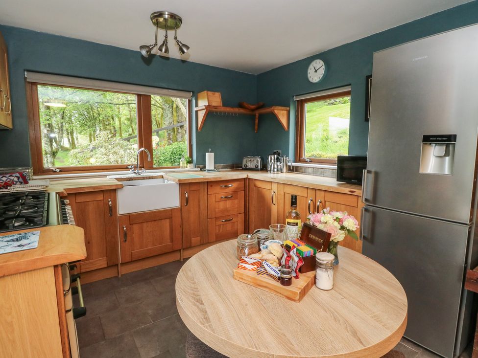 A kitchen with a sink and fridge at Puidrac Cottage in Balquhidder