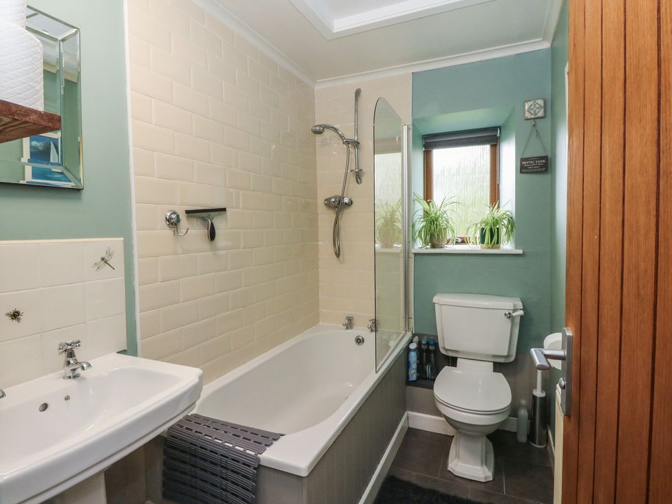 A bathroom with bath tub, shower, and toilet at Puidrac Cottage Balquhidder