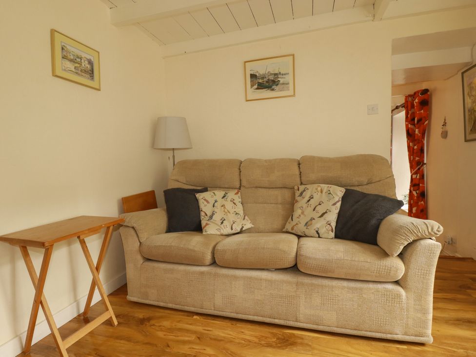 A living room with a sofa and table at Vi’s Valley View in Pentewan