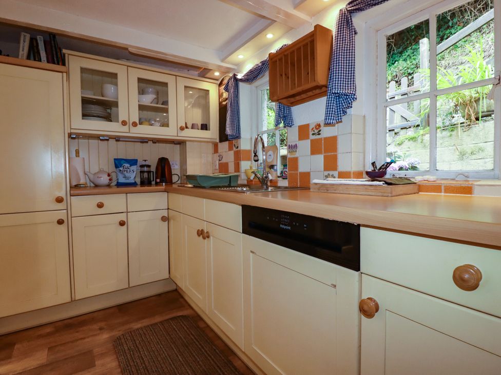 A kitchen with cabinets and a sink at Vi’s Valley View Pentewan