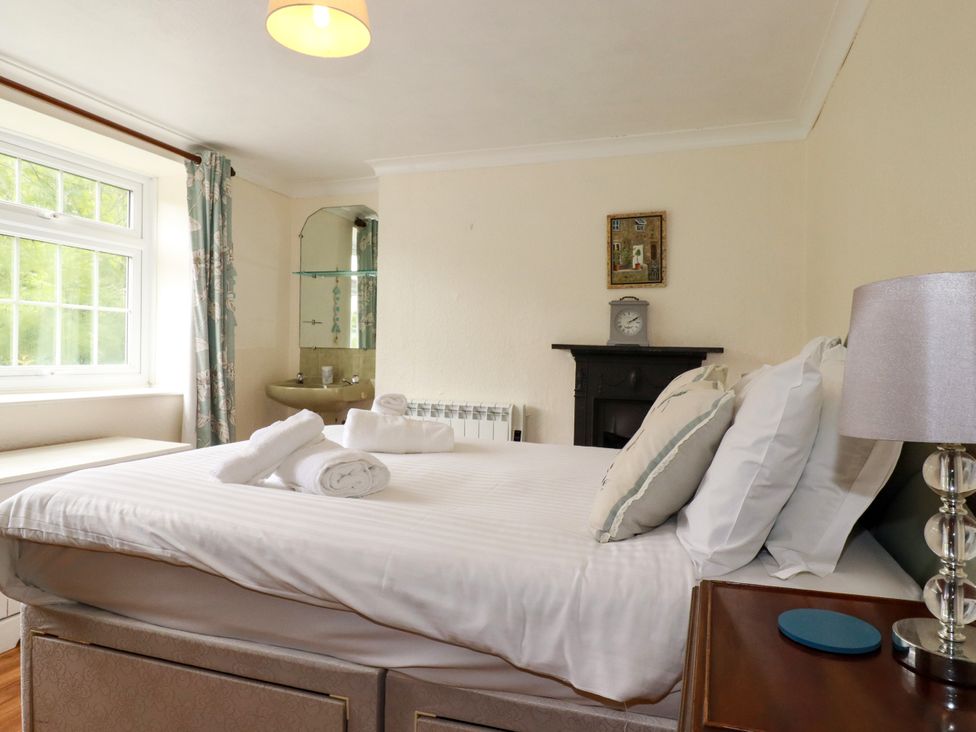 A bedroom with a bed and window at Vi’s Valley View in Pentewan