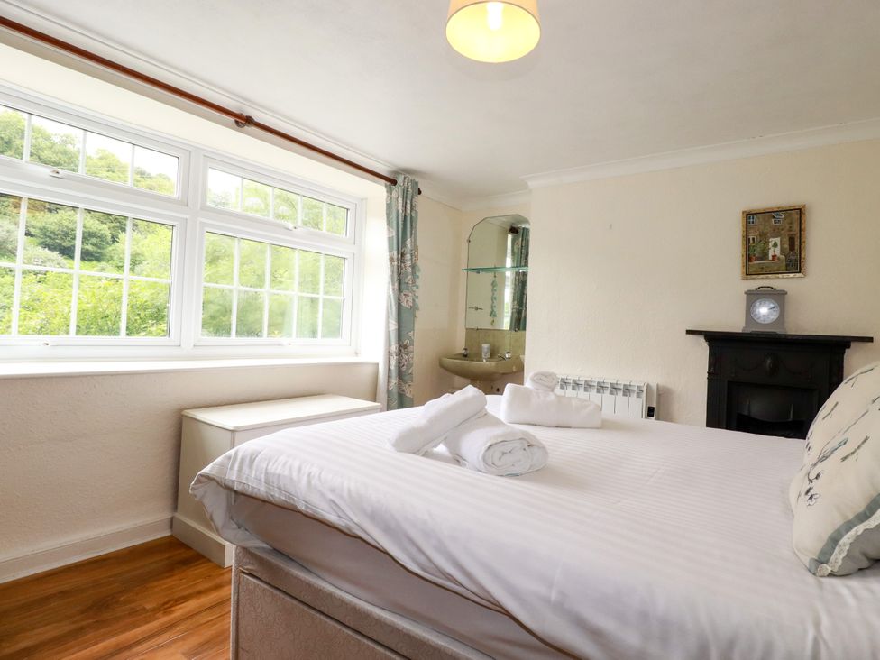 A bedroom with a bed and window at Vi’s Valley View in Pentewan