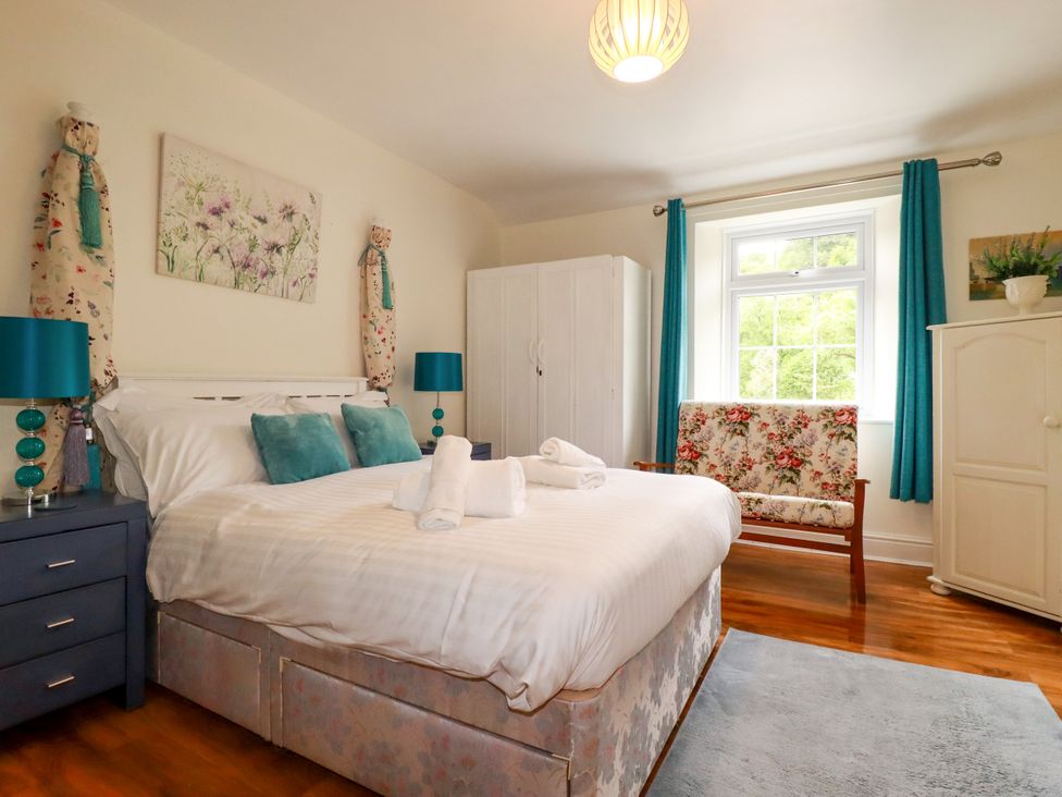 A bedroom with a bed and chair at Vi’s Valley View, Pentewan
