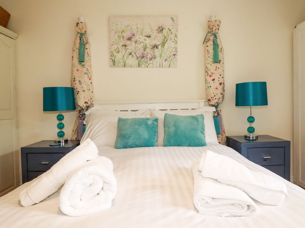 A bedroom with a bed and blue lamps at Vi’s Valley View in Pentewan