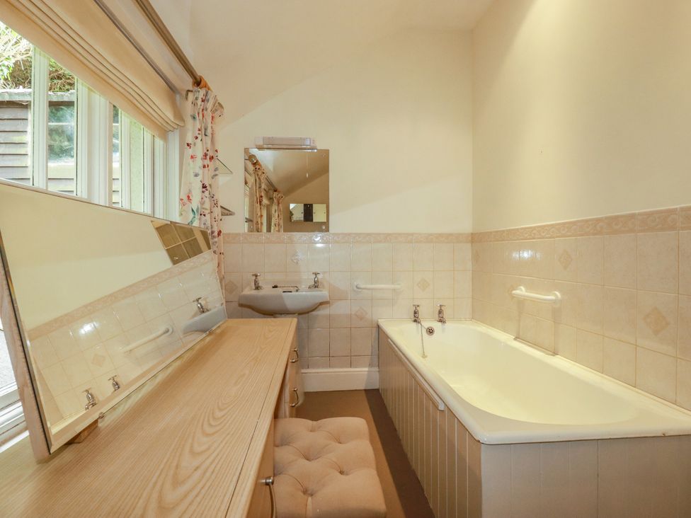 A bathroom with a bathtub and a sink at Vi’s Valley View in Pentewan