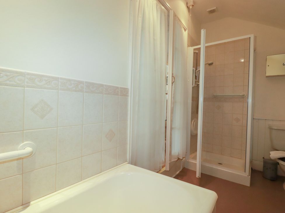 A bathroom featuring a bathtub, shower, and toilet at Vi’s Valley View, Pentewan