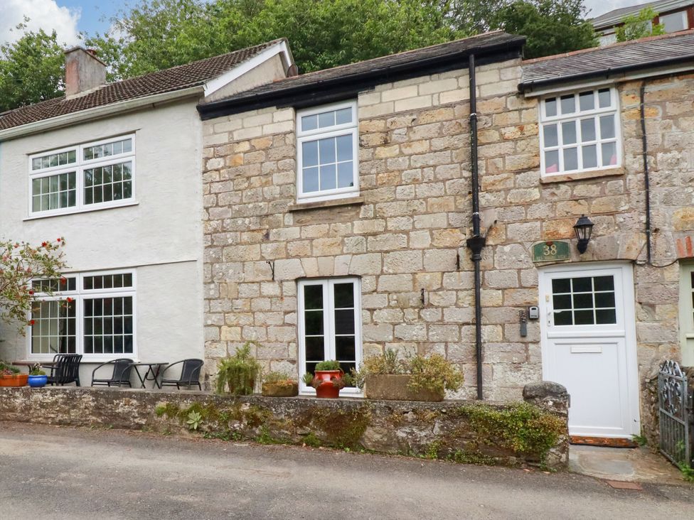 A residential exterior with stone wall and windows at Vi’s Valley View in Pentewan