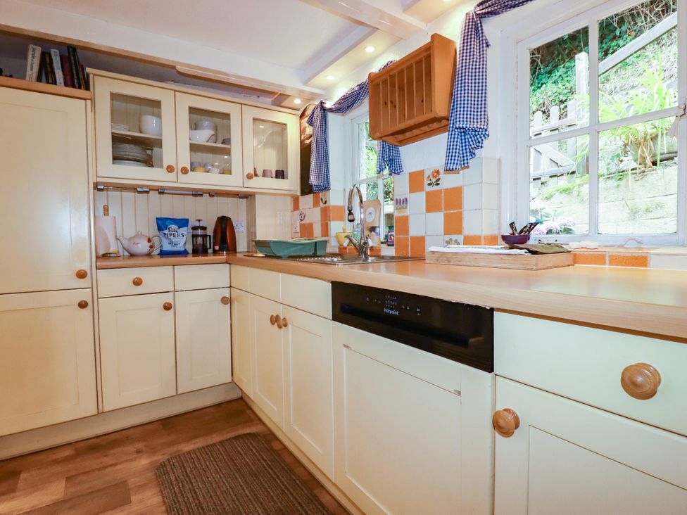 A kitchen with a sink and cupboards at Vi’s Valley View in Pentewan