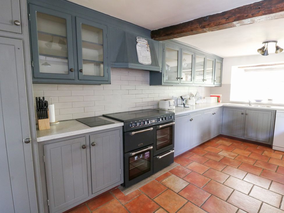 A kitchen with cabinets, stove, and sink at Penarth in Cregrina near Builth Wells