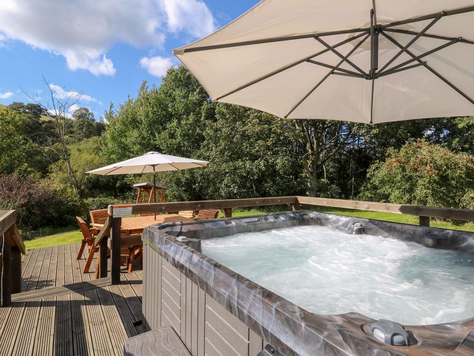A hot tub on a wooden deck in the garden at Penarth, Cregrina near Builth Wells