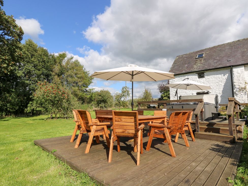 A garden with wooden furniture and parasols at Penarth, Cregrina near Builth Wells
