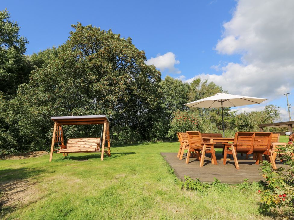 A garden with a swing and seating area at Penarth in Cregrina near Builth Wells
