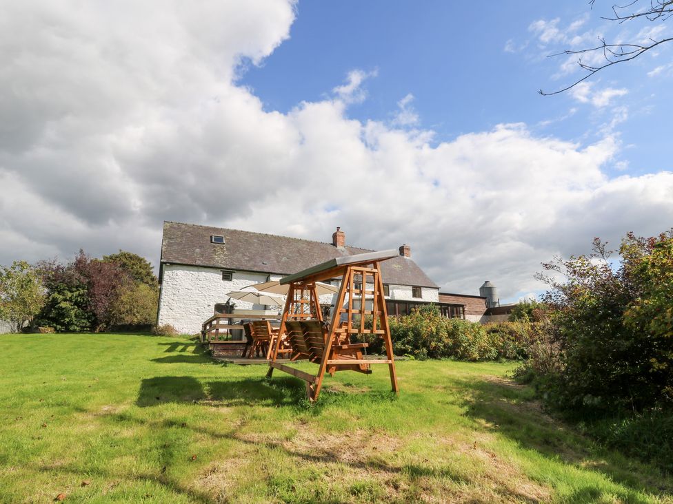 A garden with a swing set and outdoor furniture at Penarth in Cregrina near Builth Wells