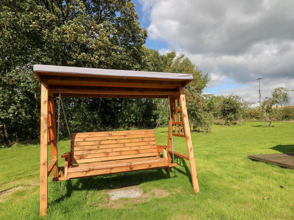 A wooden swing with a roof in a garden at Penarth in Cregrina near Builth Wells