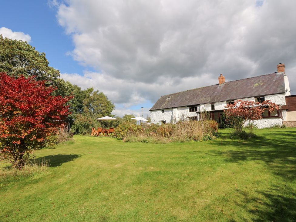 A garden with a house and outdoor seating at Penarth Cregrina near Builth Wells