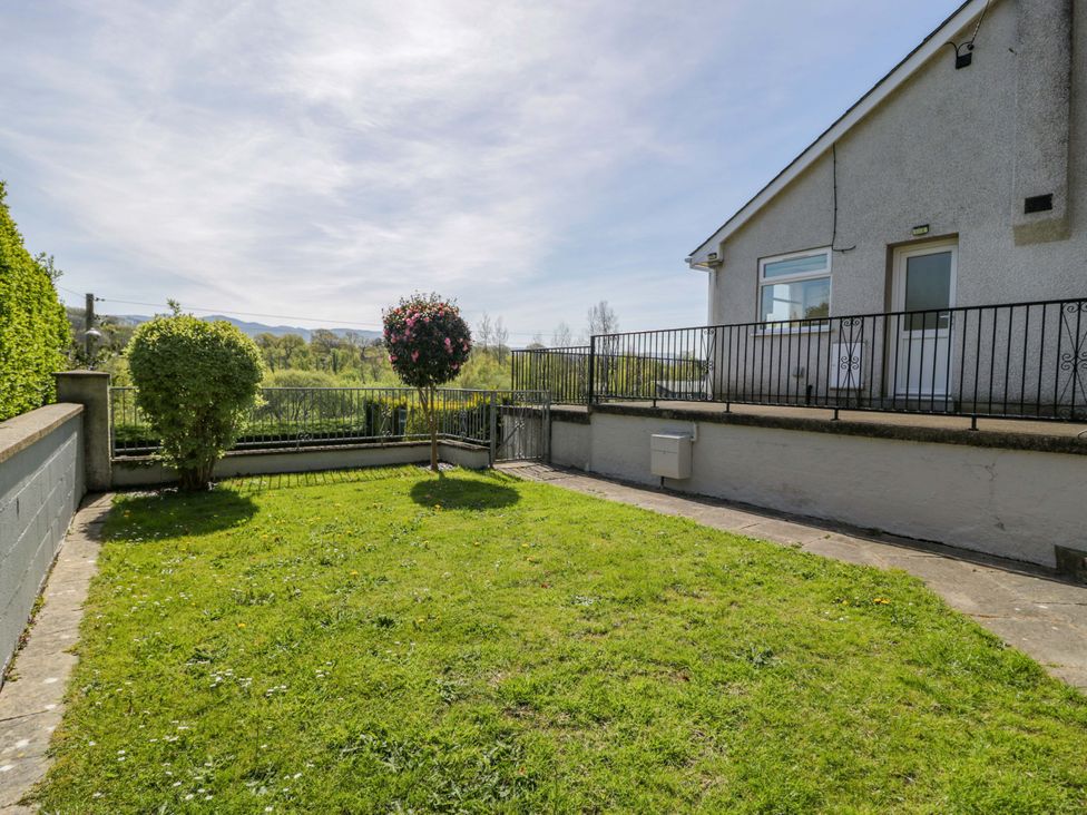 A garden with grass and a bush at Trem Y Foel in Penrhyndeudraeth