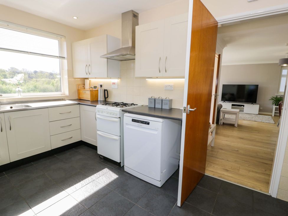 A kitchen with a sink oven and dishwasher at Trem Y Foel in Penrhyndeudraeth