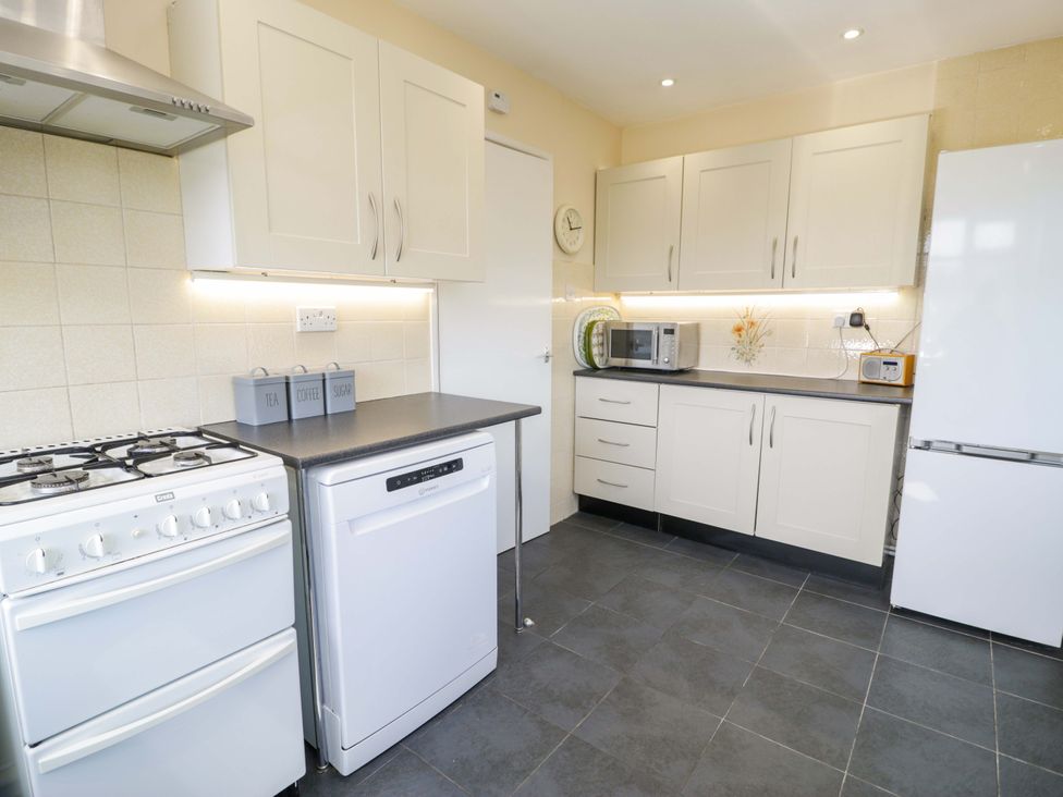 A kitchen with appliances including oven, microwave, and refrigerator at Trem Y Foel Penrhyndeudraeth