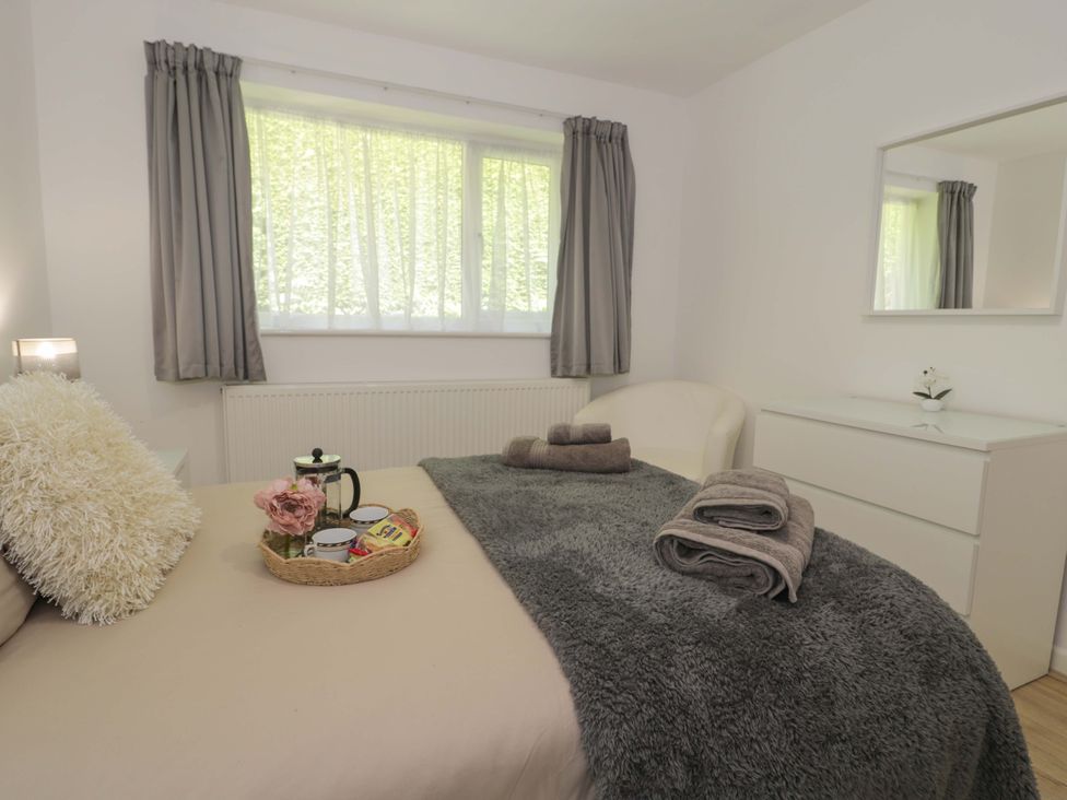 A bedroom with a bed, dresser, and chair at Trem Y Foel in Penrhyndeudraeth