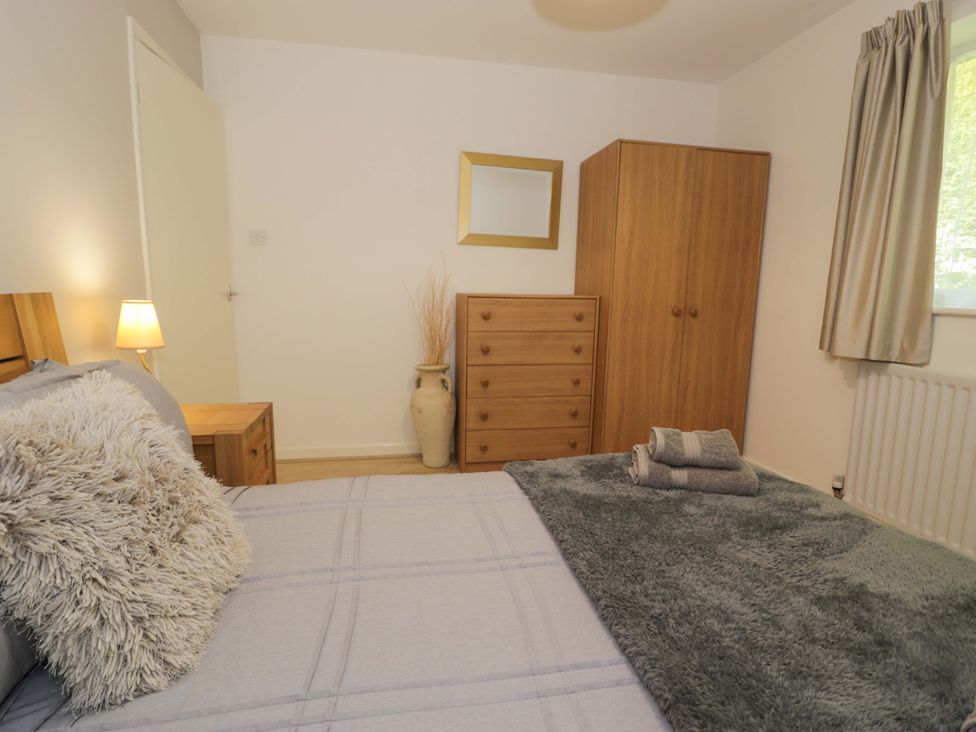 A bedroom with a bed, furniture, and decorations at Trem Y Foel in Penrhyndeudraeth