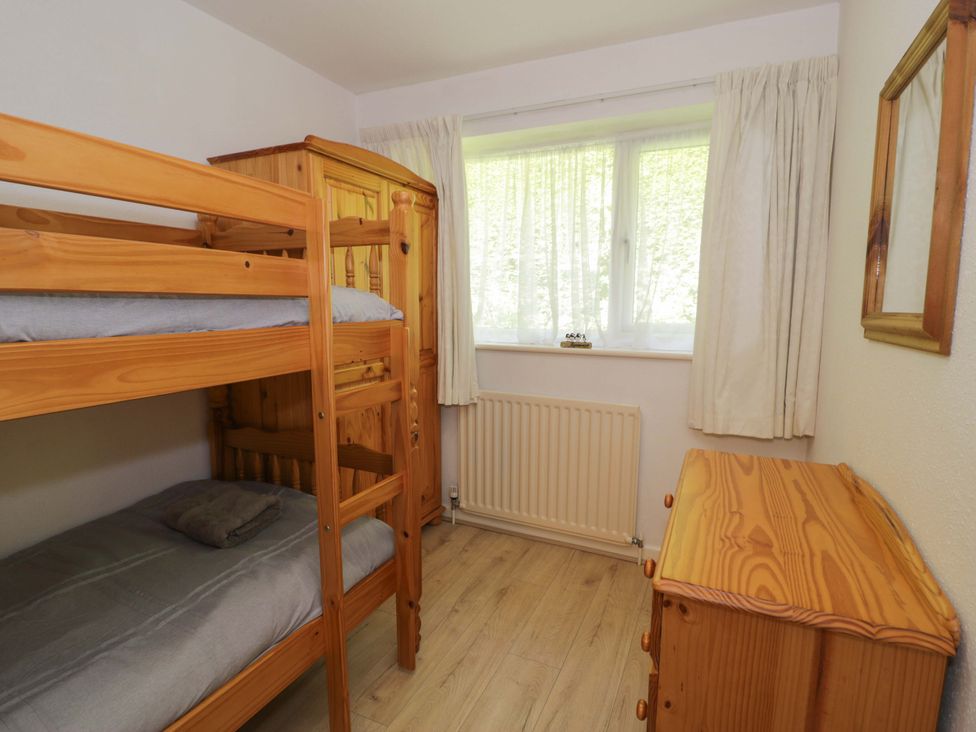 A bedroom with a bunk bed and a wooden dresser at Trem Y Foel in Penrhyndeudraeth
