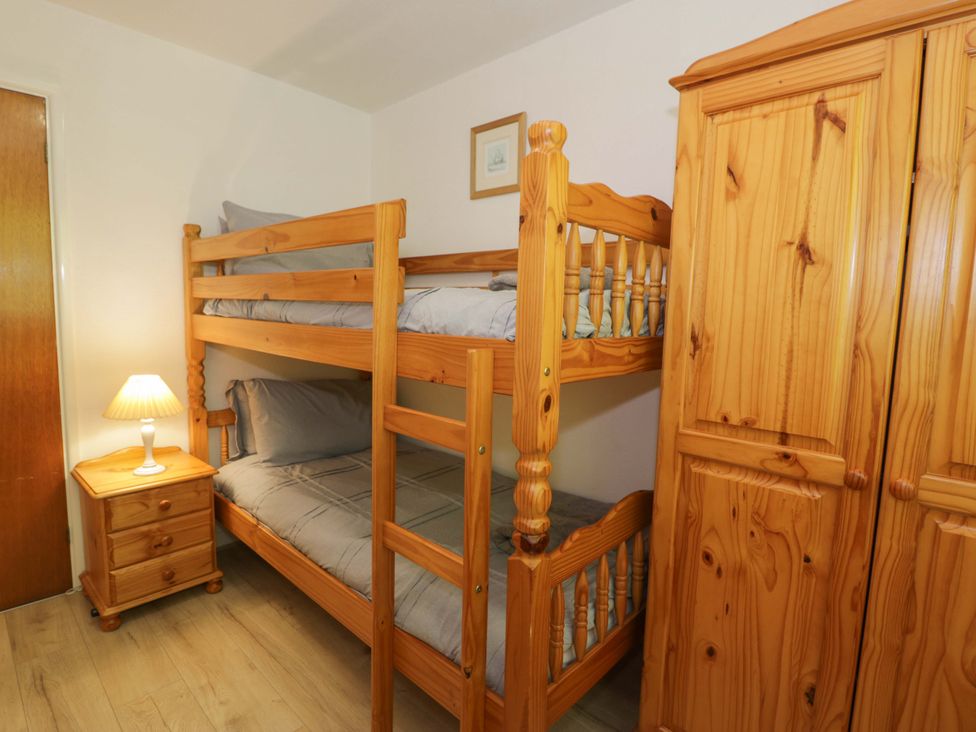 A bedroom with a bunk bed and bedside table at Trem Y Foel in Penrhyndeudraeth
