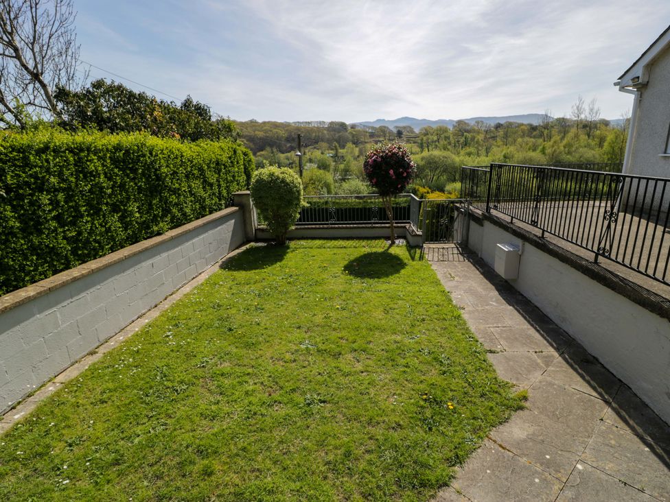 A garden with grass and a flower pot at Trem Y Foel in Penrhyndeudraeth