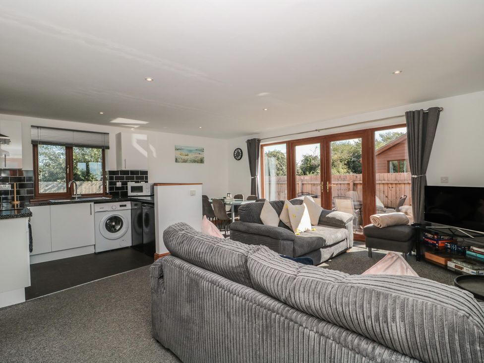 A living room with a sofa and kitchen area at Bluebell Lodge, Meadow view lodges in Brean