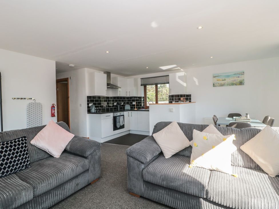 A living room with a kitchen area and seating at Bluebell Lodge, Meadow view lodges Brean