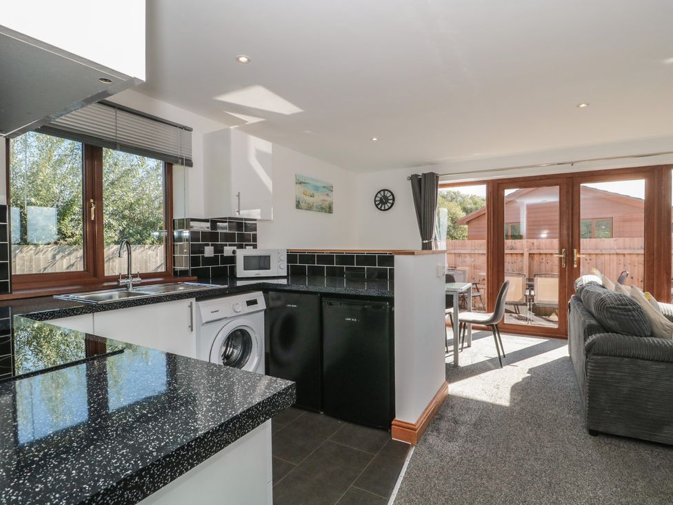 A kitchen with appliances and seating at Bluebell Lodge, Meadow view lodges Brean